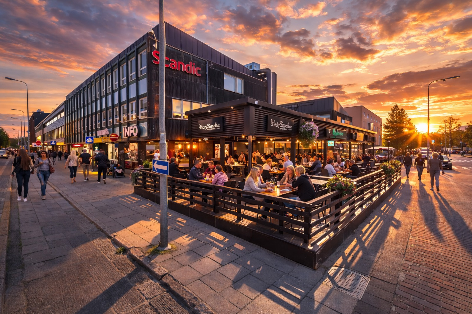 Belebtes Terrassencafé bei Sonnenuntergang an einer modernen Straßenecke mit warm beleuchteten Fenstern, vielen Gästen an Tischen, Spaziergängern auf dem Gehweg und goldenem Abendhimmel