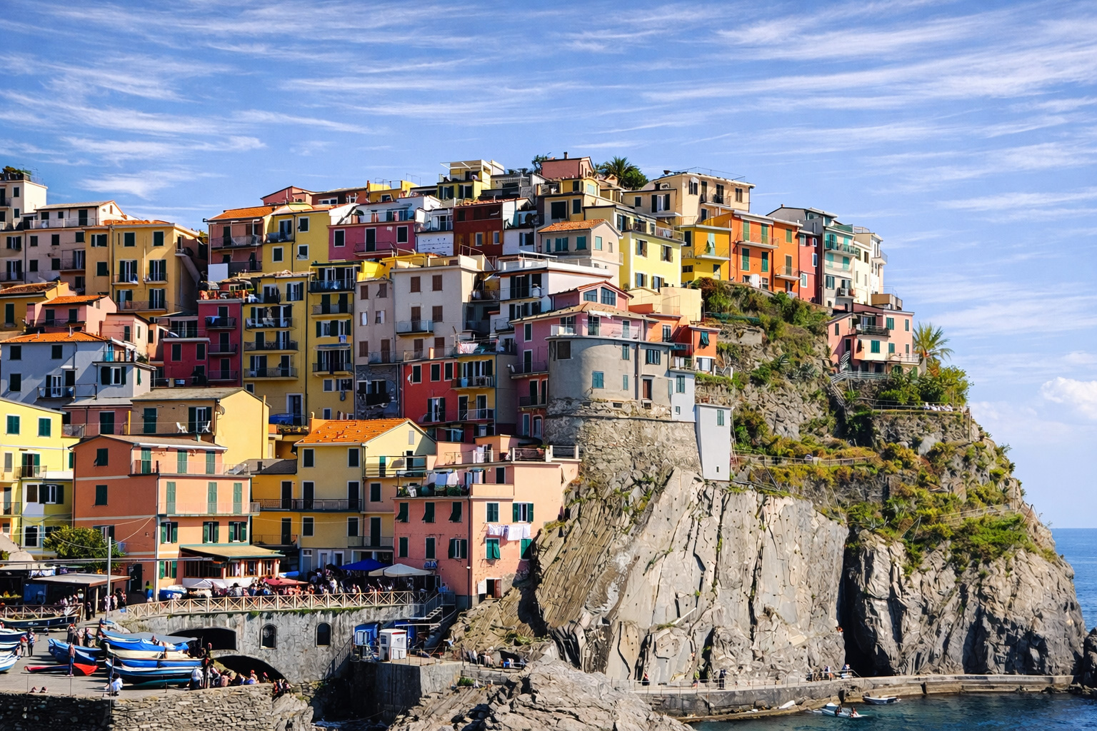 Panorama von Manarola zu den Cinque Terre mit buten Häusern an den Felsen direkt am Meer.