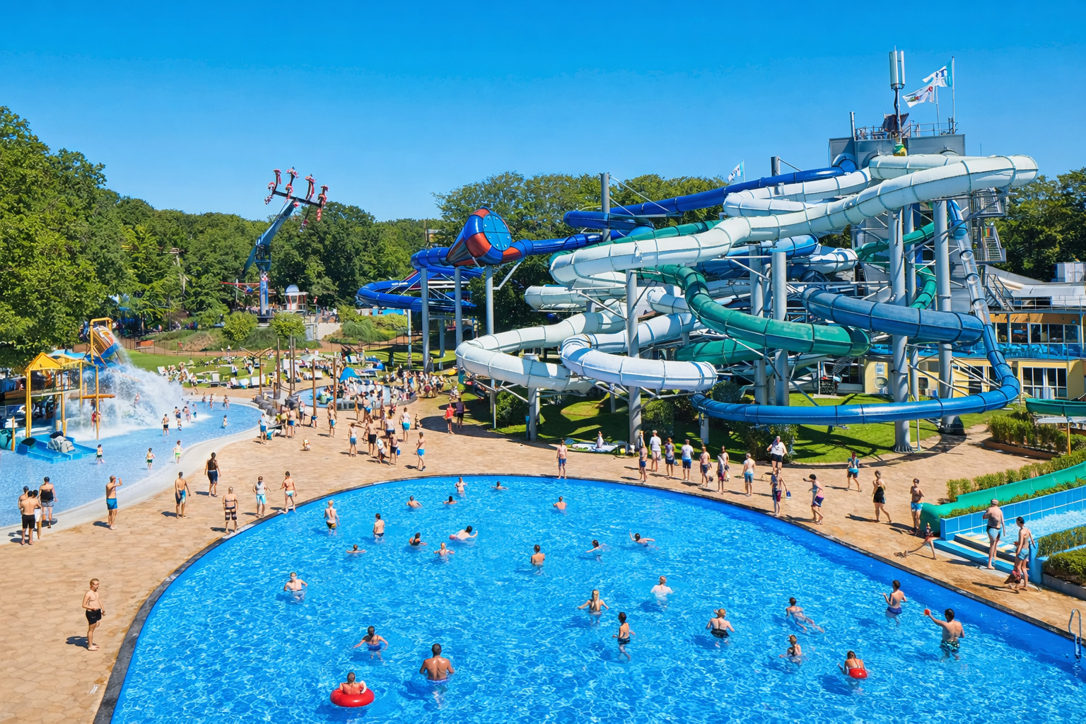 Blick auf das Freibad von Duinrell mit großem Wellenbecken, vielen Badegästen und Schwimmringen im klaren Wasser, weit verzweigten Röhrenrutschen in Blau und Türkis über der Anlage sowie sonniger Liegewiese und Freizeitattraktionen am Waldrand