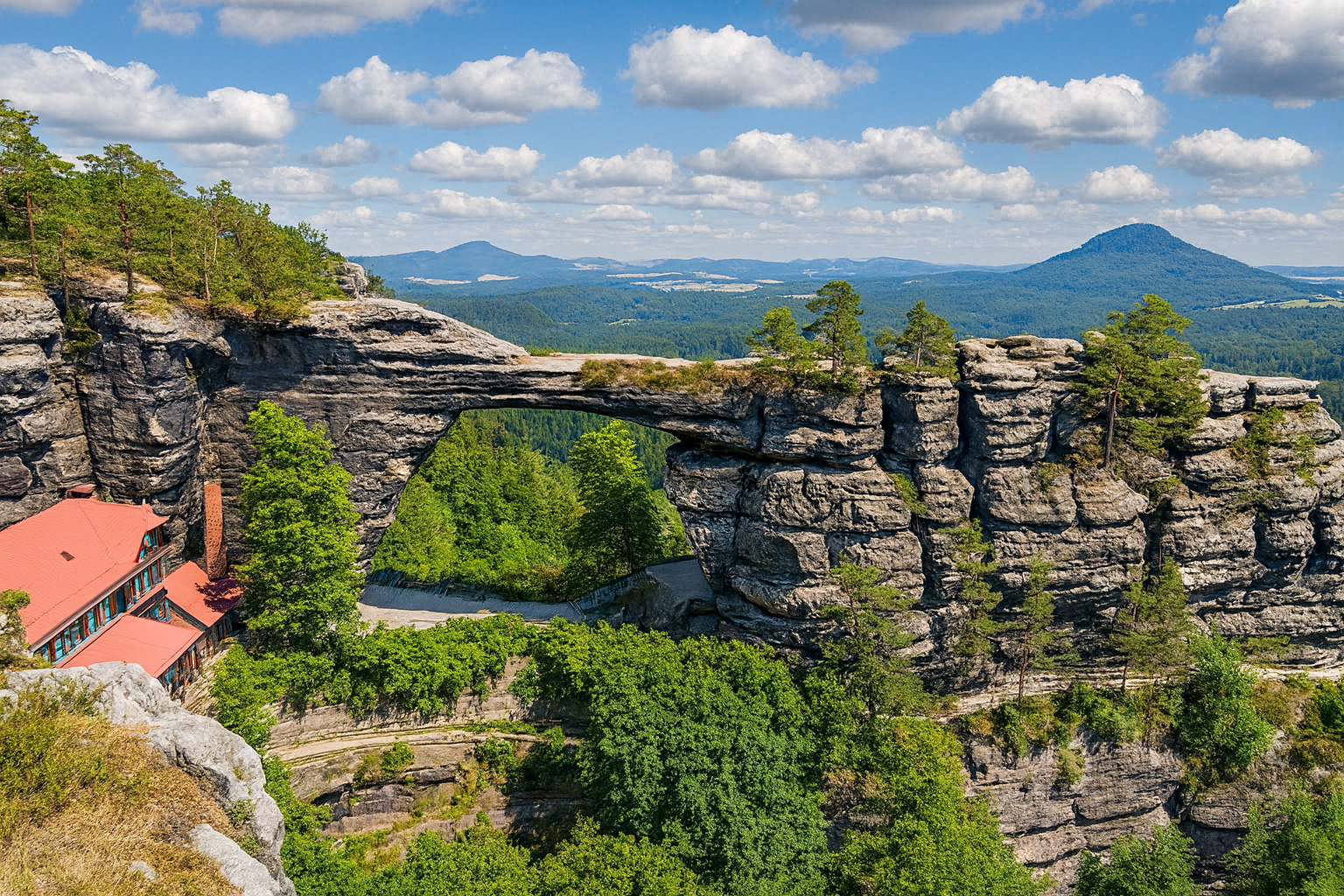Aussichtspunkt Prebischtor im Elbsandsteingebirge mit malerischen weiß-grauen Wolken und sonniger Landschaft