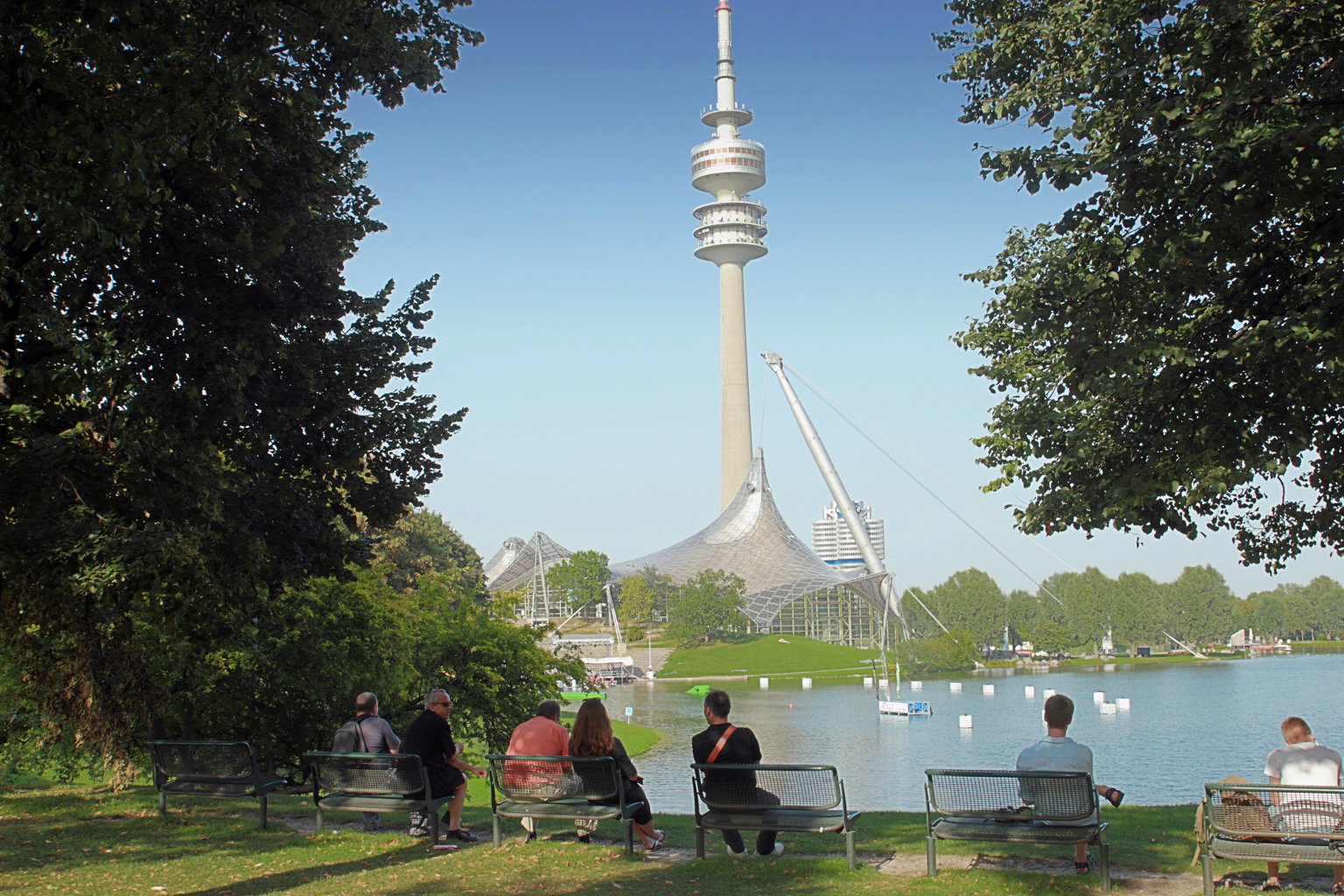 Der Olympiapark in München mit dem See und den Olympiaturm im Hintergrund