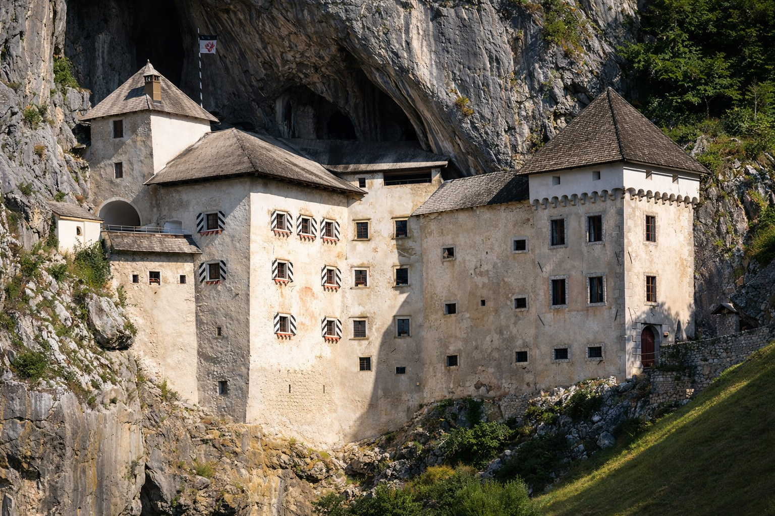 Panoramabild auf die Predjama Burg in einem Felsen.