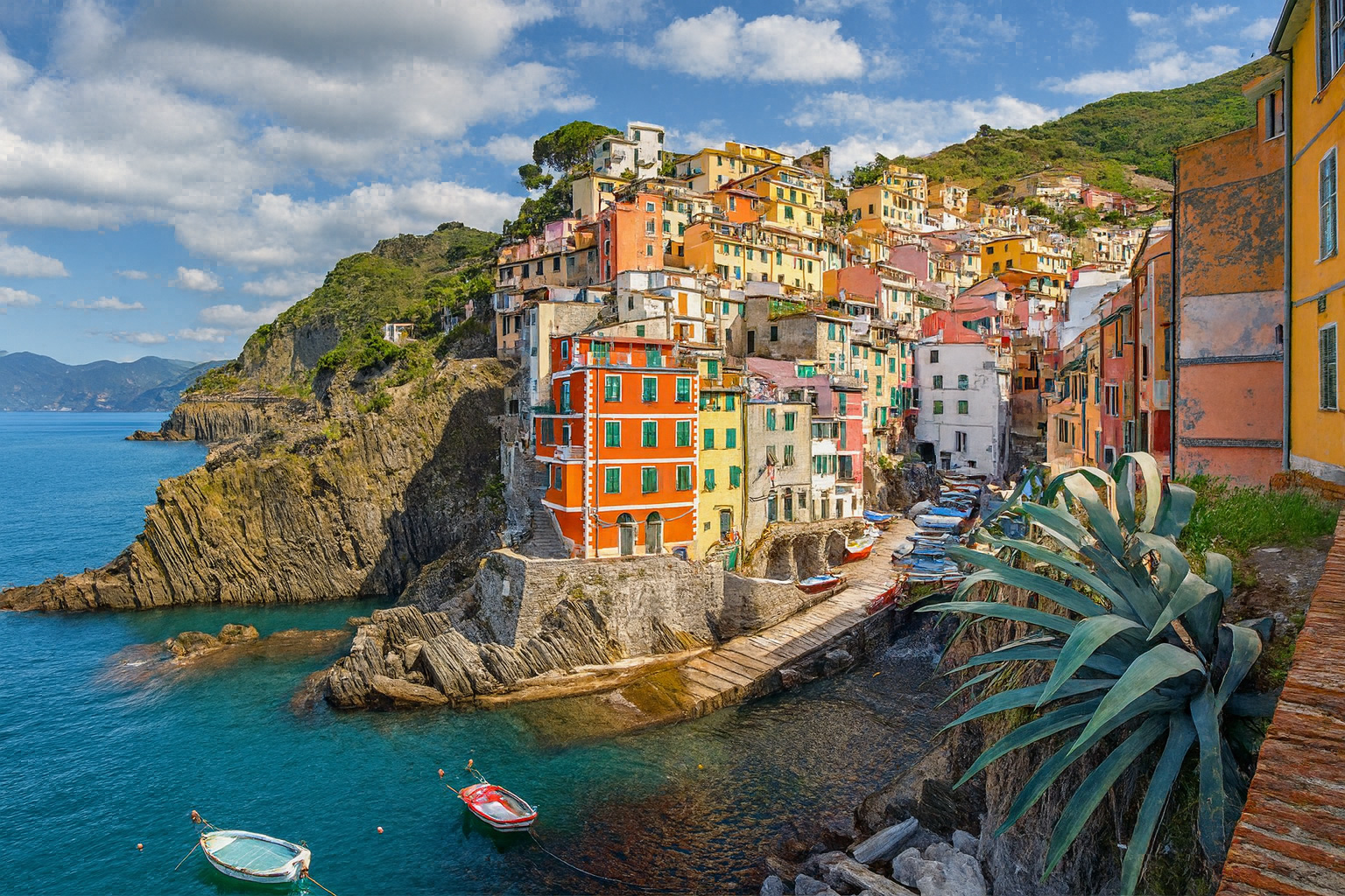 Panorama der Stadt Riomaggiore in Cinque Terre mit bunten Häusern über dem Meer unter malerischen weiß-grauen Wolken im besten Sonnenlicht.