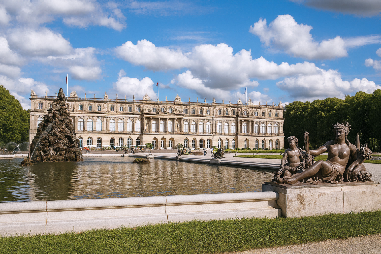 Schloss Herrenchiemsee mit Brunnen und Statuen, umgeben von malerischen weiß-grauen Wolken bei hellem Sonnenlicht