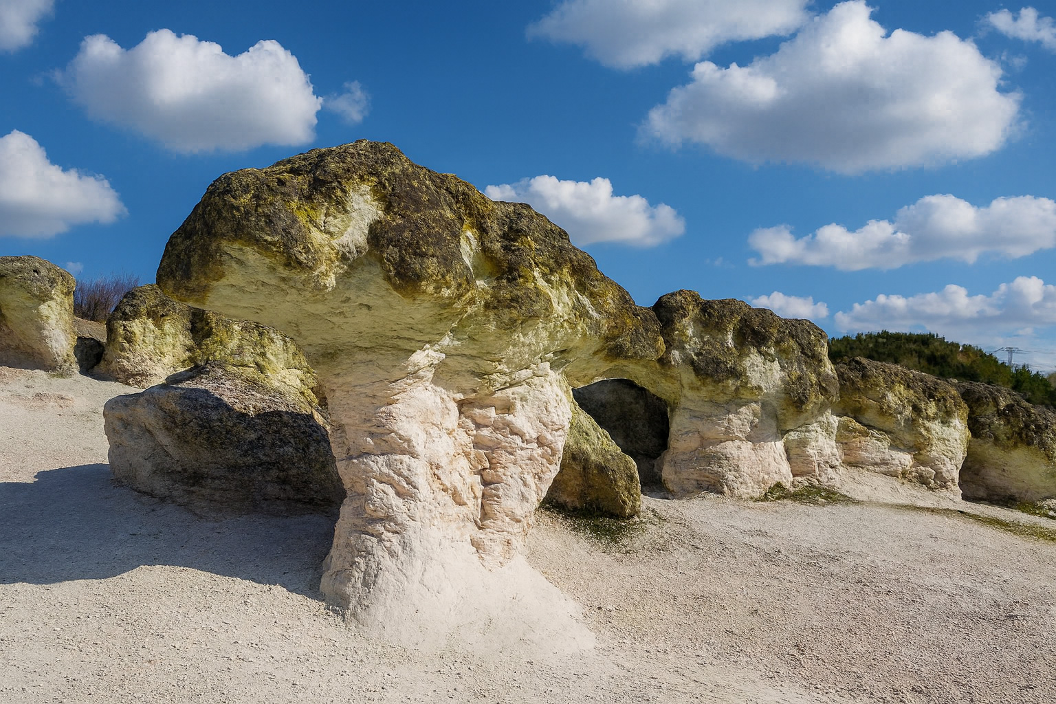 Die Stone Mushrooms in Bulgarien unter blauem Himmel mit weißen Wolken, ihre charakteristische pilzartige Form aus hellem Gestein leuchtet im Sonnenlicht