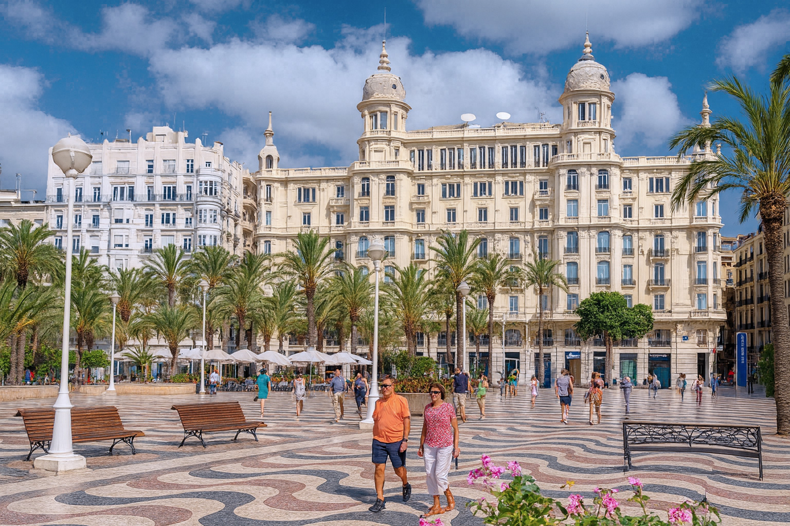 Casa Carbonell an der Explanada de España in Alicante mit Palmen, Spaziergängern und malerischen weiß-grauen Wolken im Sonnenlicht.
