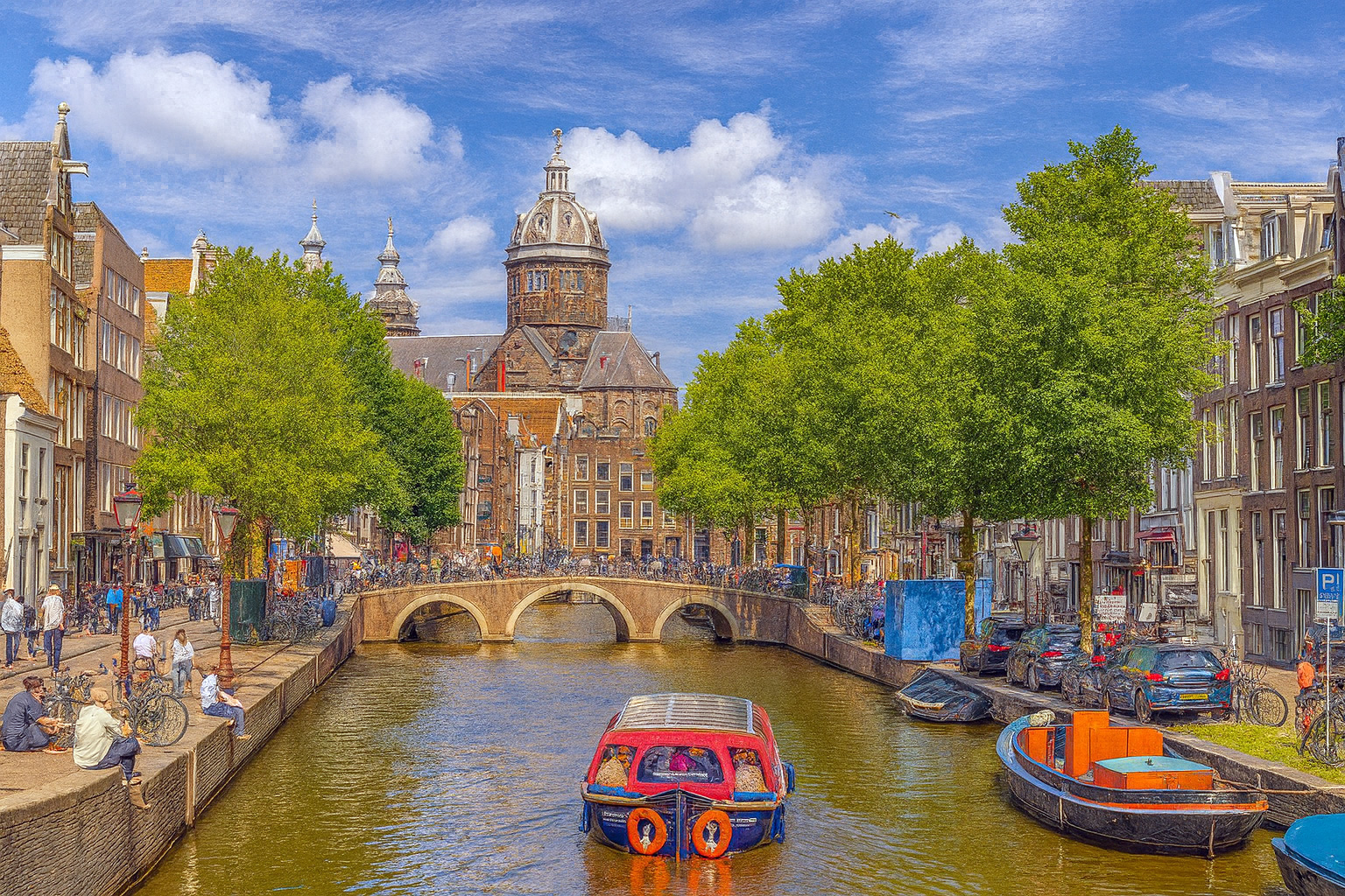 Panorama der Armbrug-Brücke in Amsterdam mit Booten auf dem Kanal und der Basilika St. Nikolaus im Hintergrund unter einem Himmel mit Zirrus- und Kumuluswolken.