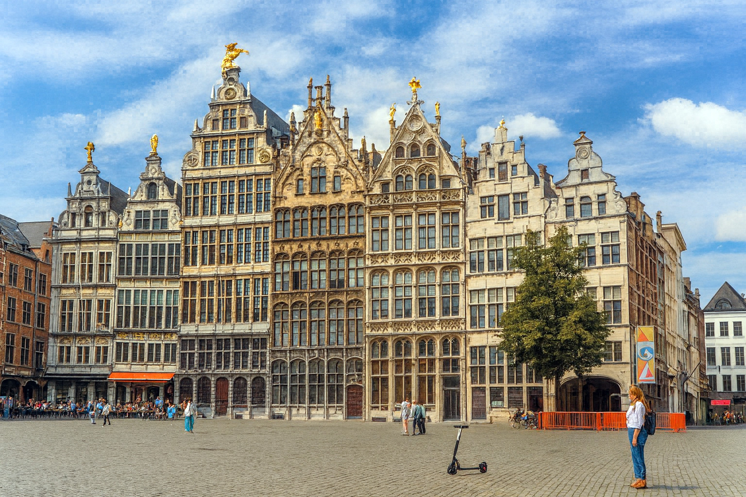 Panorama des Grote Markt in Antwerpen mit historischen Giebelhäusern im Sonnenlicht unter einem Himmel mit Zirrus- und Cumuluswolken.