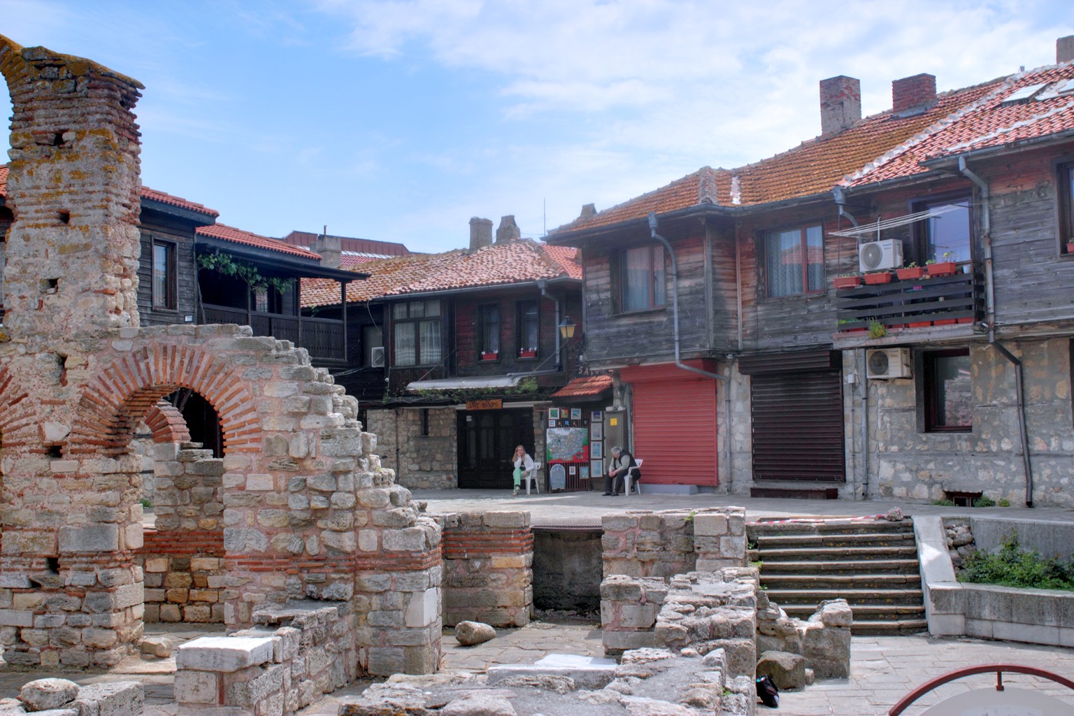 Die Altstadt von Nessebar mit Holzarchitektur und einer historischen Ruine aus der byzantinischer Zeit.