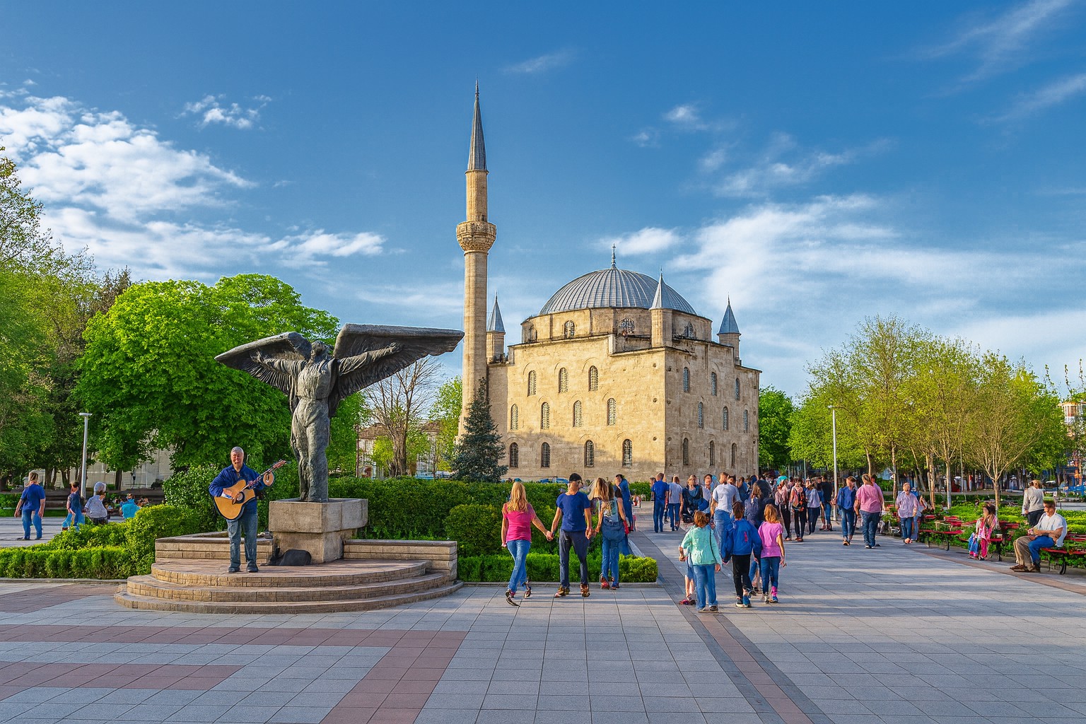 Ibrahim-Pascha-Moschee in Rasgrad mit byzantinischer Architektur, Minarett und belebtem Platz mit Spaziergängern bei Sonnenschein.