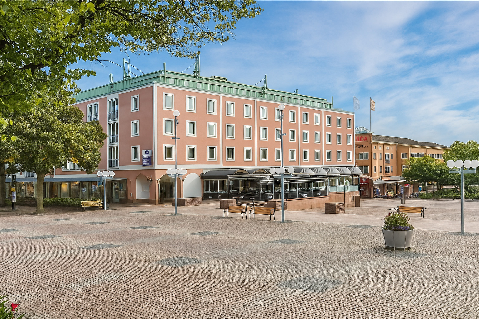 Stadtplatz in Tranås mit rosa Gebäude und Straßencafé unter einem Himmel mit Zirrus- und Kumuluswolken bei sonnigem Wetter.
