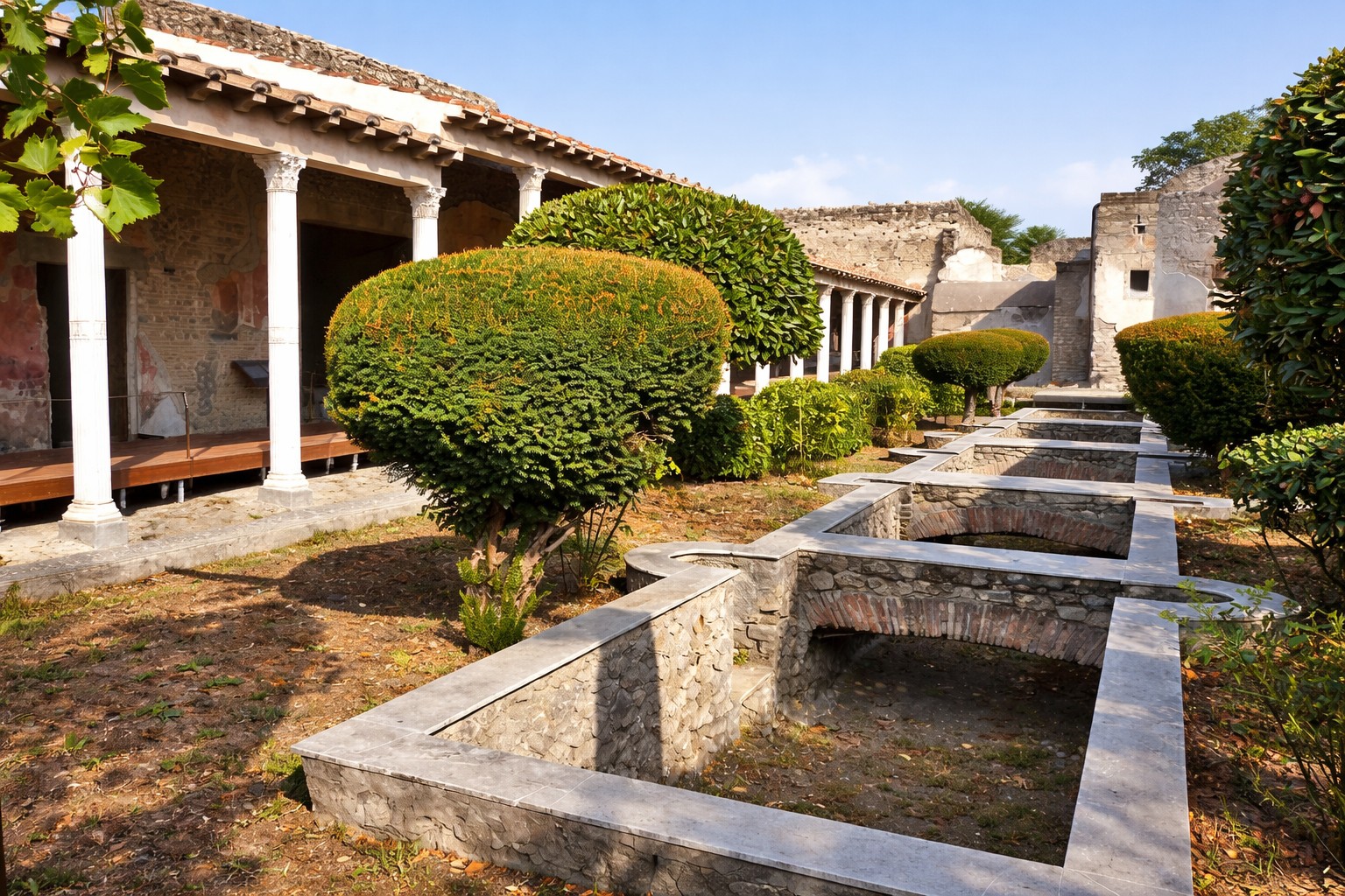 Gartenanlage der Praedia di Giulia Felice in Pompei mit rechteckigen Wasserbecken, geschnittenen Sträuchern, Säulenportikus und Blick entlang der antiken Wohn- und Gartenarchitektur unter klarem Himmel