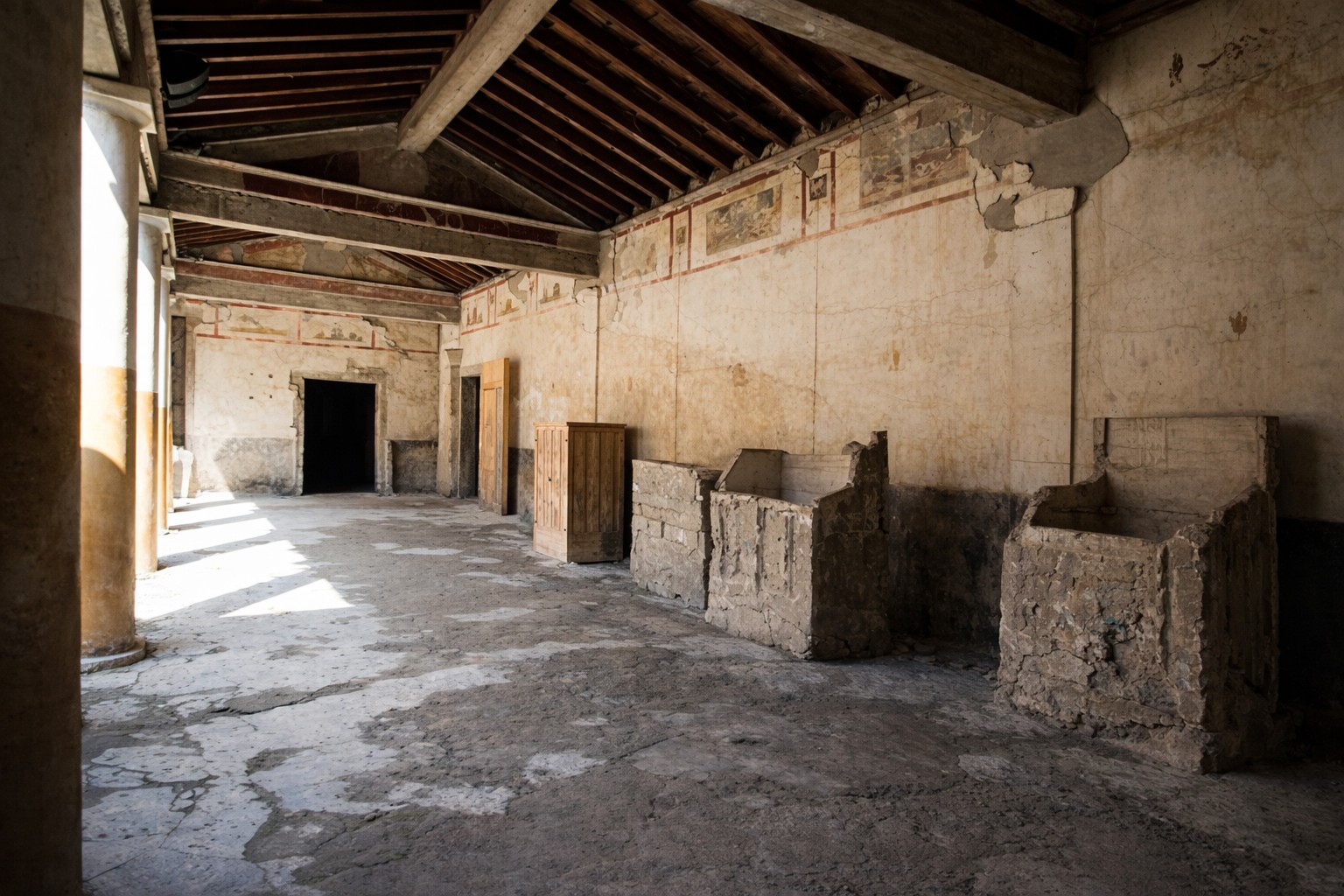 Innenraum der Casa di Giulio Polibio in Pompeji mit langem Säulengang, steinernen Herd- und Lagerelementen, Holzdecke und erhaltenen Wandmalereien entlang der Wände